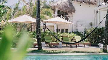 Una piscina al aire libre, sillones reclinables de piscina