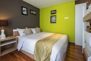A modern hotel room with a large bed, a bedside table, and a lamp. - Yans House Hotel Bali (Kuta)