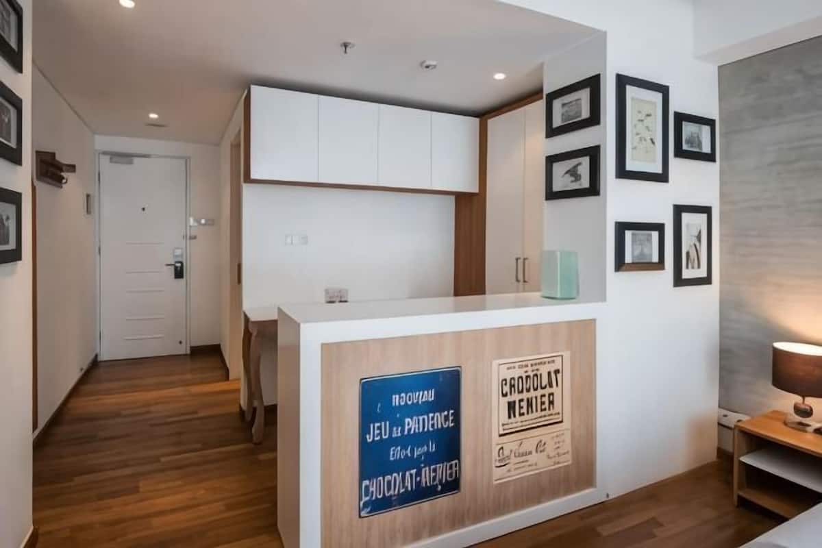 Una recepción con un cartel, cuadros en la pared y suelo de madera.