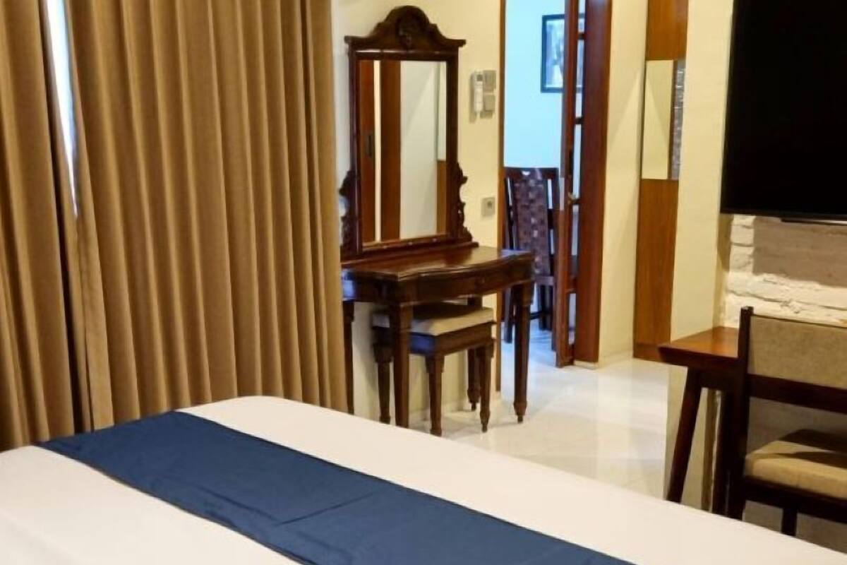 Ein Hotelzimmer mit Bett, Schreibtisch und Stuhl.