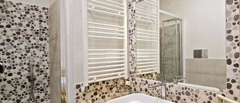 A modern bathroom with a freestanding bathtub, a shower, and a large mirror.