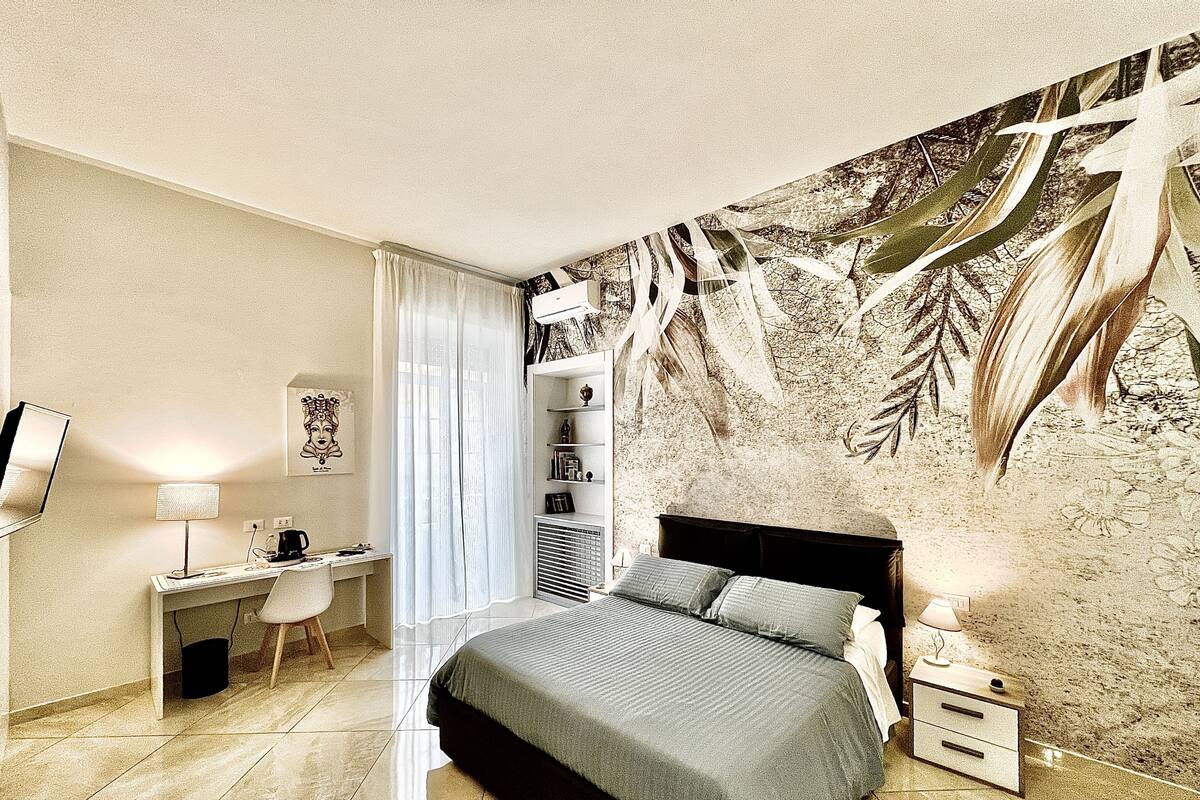 Un dormitorio moderno con una cama grande, un escritorio y un televisor.