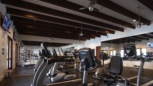 Un gimnasio con cintas de correr, elípticas y equipo de pesas.