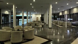 En rummelig lobby med moderne møbler, en skinnende gulv og et højt loft med indbygget belysning.