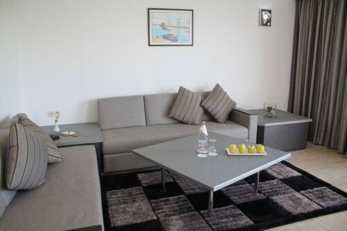 A modern living room with a grey sofa, a coffee table, and a small side table.