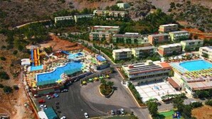 Eine Luftaufnahme eines Resorts mit mehreren Gebäuden, einem Swimmingpool und einem Parkplatz.
