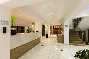 A hotel lobby with a reception desk, a staircase, and a seating area. - Kahlua Boutique Hotel (Hersonissos)