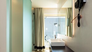 Une salle de bain moderne avec un grand miroir, un lavabo et un téléphone.