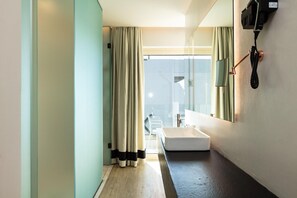 Ein modernes Badezimmer mit einem großen Spiegel, einem Waschbecken und einem Telefon.