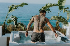 A person standing in a hot tub with a view of the ocean. - Kahlua Boutique Hotel (Hersonissos)