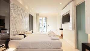 Une chambre d’hôtel moderne avec un grand lit, un téléviseur fixé au mur et un mur décoratif en marbre.