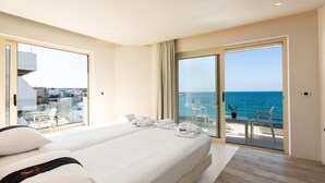 A hotel room with a bed, a balcony with a view of the sea, and a glass door leading to the balcony. - Kahlua Boutique Hotel (Hersonissos)