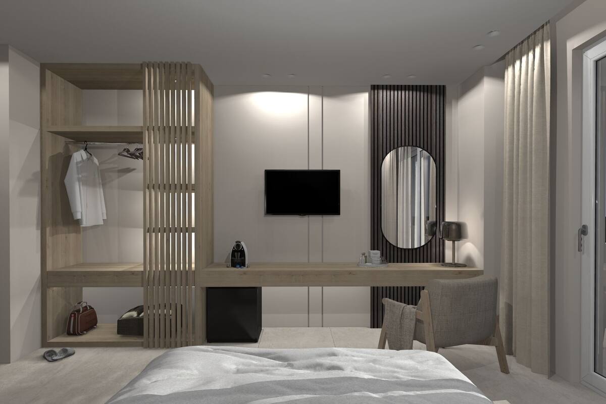 A modern bedroom with a bed, a TV, a mirror, a desk, and a wardrobe.
