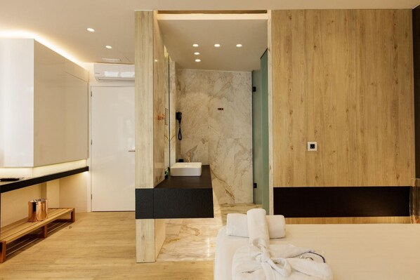 A modern bathroom with a marble vanity, a shower area, and a wooden bench. - Kahlua Boutique Hotel (Hersonissos)