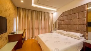 A hotel room with a large bed, a desk, and a TV. - Yiwu Chuzhou Hotel (Jinhua)