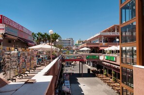 Una calle con terrazas, un restaurante y un edificio de Visa.