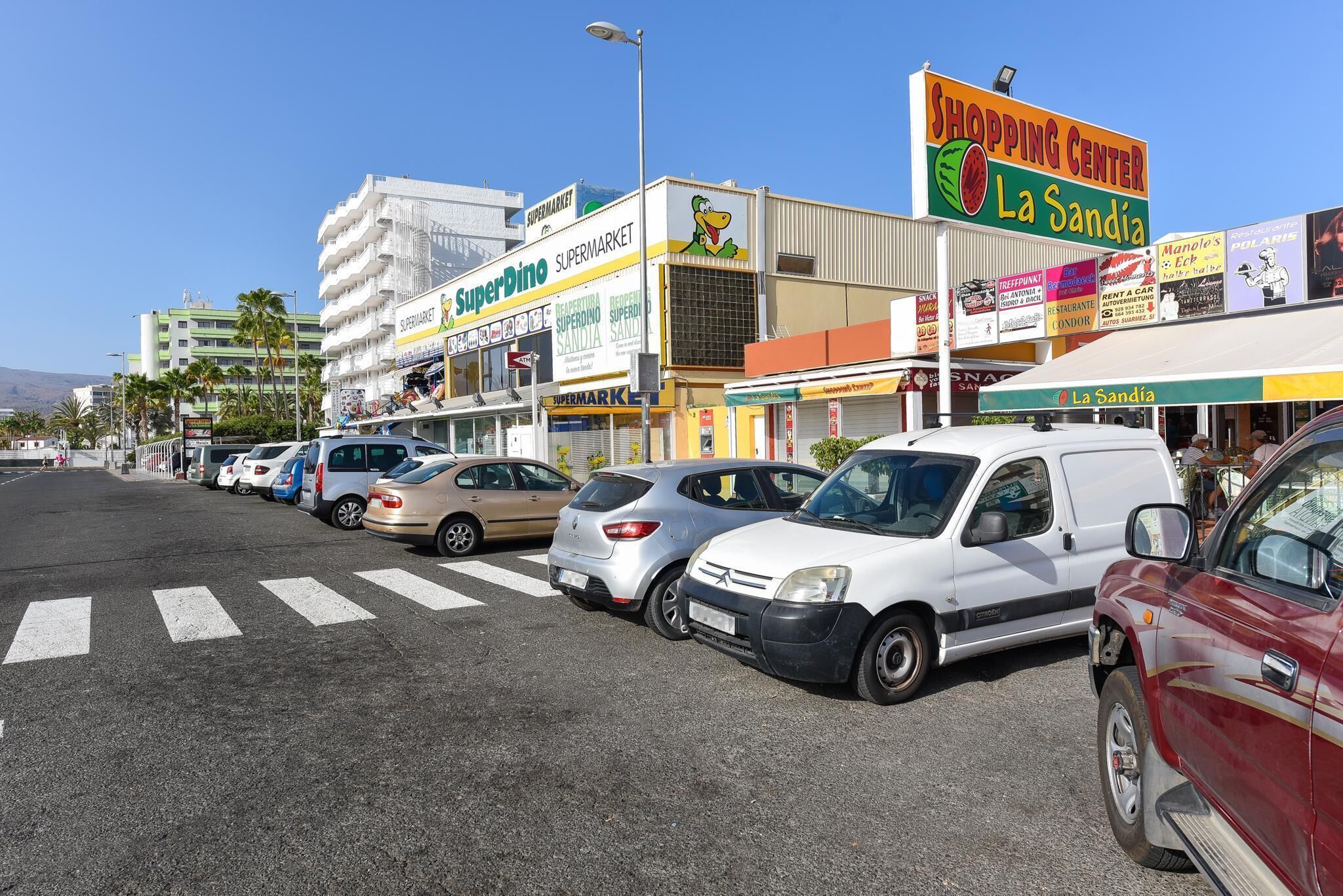 Een winkelcentrum met verschillende winkels, waaronder een supermarkt en een restaurant.