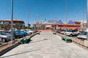 Un estacionamiento que conduce a un centro comercial con un letrero distintivo.
