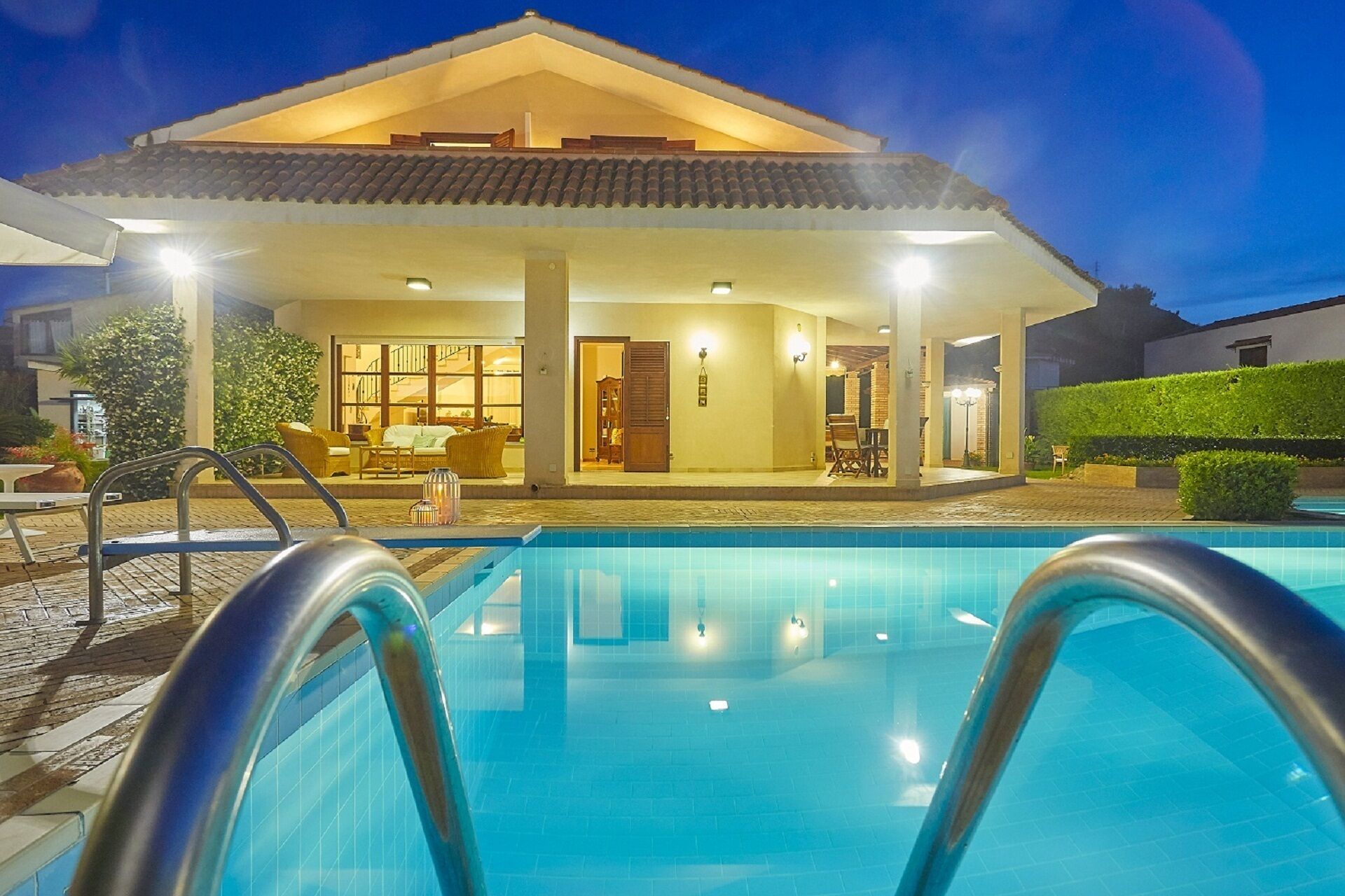 Una piscina con una casa al fondo.