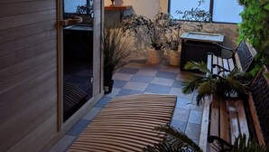 A modern interior with a wooden wall, a bench, and potted plants. - The River Inn Thredbo (Thredbo)