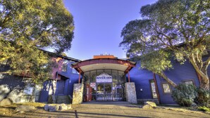A River Inn building with a sign, an ATM, and a Coca-Cola sign. - The River Inn Thredbo (Thredbo)