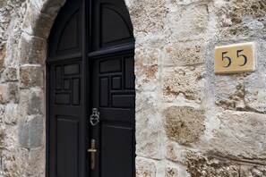 Traditional stone building with a black door and brass hardware.