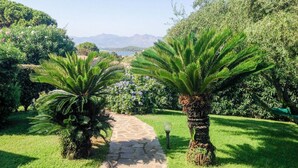 A garden pathway leading to a scenic view with mountains in the background.
