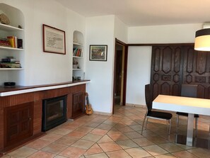 Una cocina con mostrador de madera, una guitarra y un comedor con mesa y sillas.