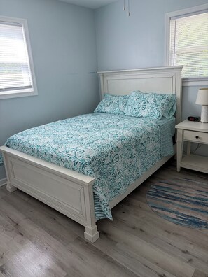 A bedroom with a bed, a nightstand, a lamp, and a clock. - *** NEWLY RENOVATED**** Escape to a Beautiful Getaway on the Chesapeake Bay (Perryville)