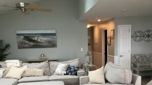 A living room with a sectional sofa, a ceiling fan, and a painting of a boat on the wall. - *** NEWLY RENOVATED**** Escape to a Beautiful Getaway on the Chesapeake Bay (Perryville)