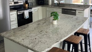 A modern kitchen with white cabinetry, stainless steel appliances, granite countertops, and bar stools. - *** NEWLY RENOVATED**** Escape to a Beautiful Getaway on the Chesapeake Bay (Perryville)