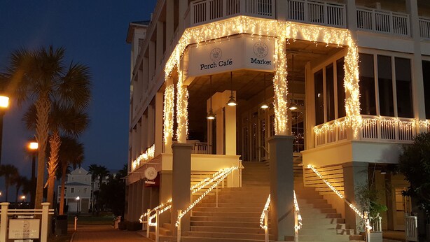 A building with a porch café and market area, featuring a staircase with string lights. - STUNNING! CUSTOM BEACH HOUSE, HOT TUB, BEACH JUST STEPS AWAY (Galveston)
