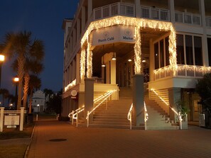A building with a porch café and market area, featuring a staircase with string lights. - STUNNING! CUSTOM BEACH HOUSE, HOT TUB, BEACH JUST STEPS AWAY (Galveston)