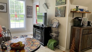 A cozy living room with a tiled coffee table, a television, and a bookshelf.