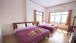 A hotel room with two beds, each with a purple bedspread and white pillows, and a wooden floor. - Mountain View House (Sangkhla Buri)