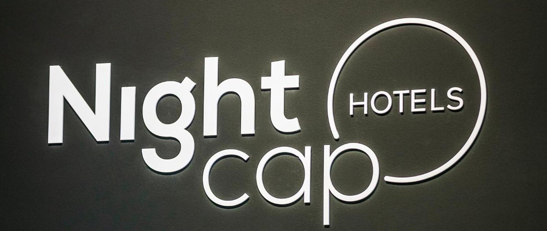 Un letrero con la inscripción 'Nightcap Hotels' en letras blancas sobre un fondo oscuro.