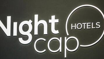 Un letrero con la inscripción 'Nightcap Hotels' en letras blancas sobre un fondo oscuro.