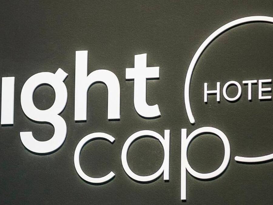 Un letrero con la inscripción 'Nightcap Hotels' en letras blancas sobre un fondo oscuro.