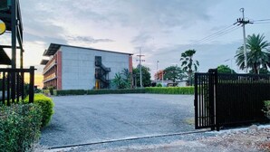 Un edificio de diseño moderno, con entrada protegida y camino de acceso pavimentado.