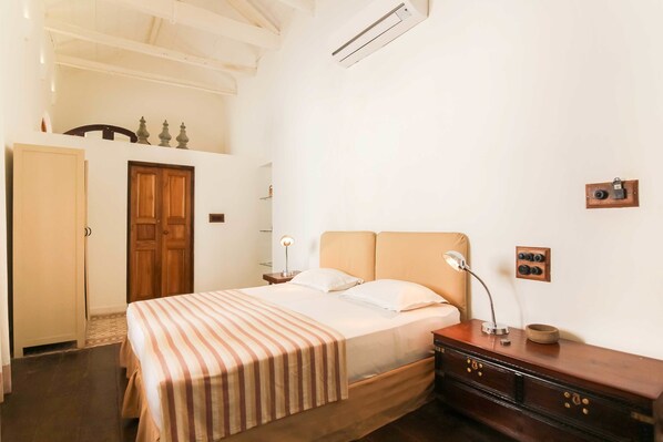 Simple, functional room with a single bed, nightstand, and dresser.