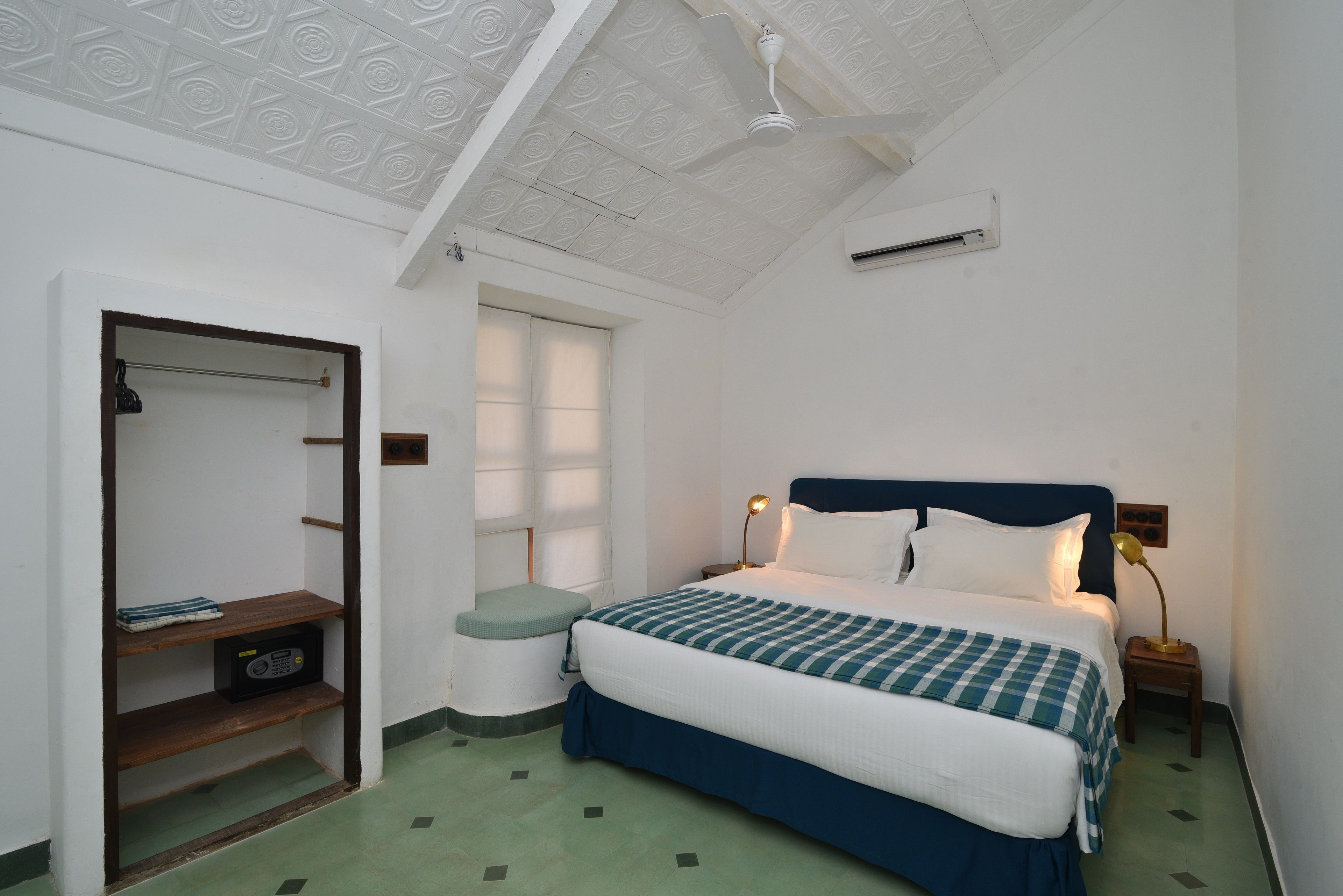 Ein Schlafzimmer mit Bett, Nachttischen, einem Kleiderschrank und einem Deckenventilator.