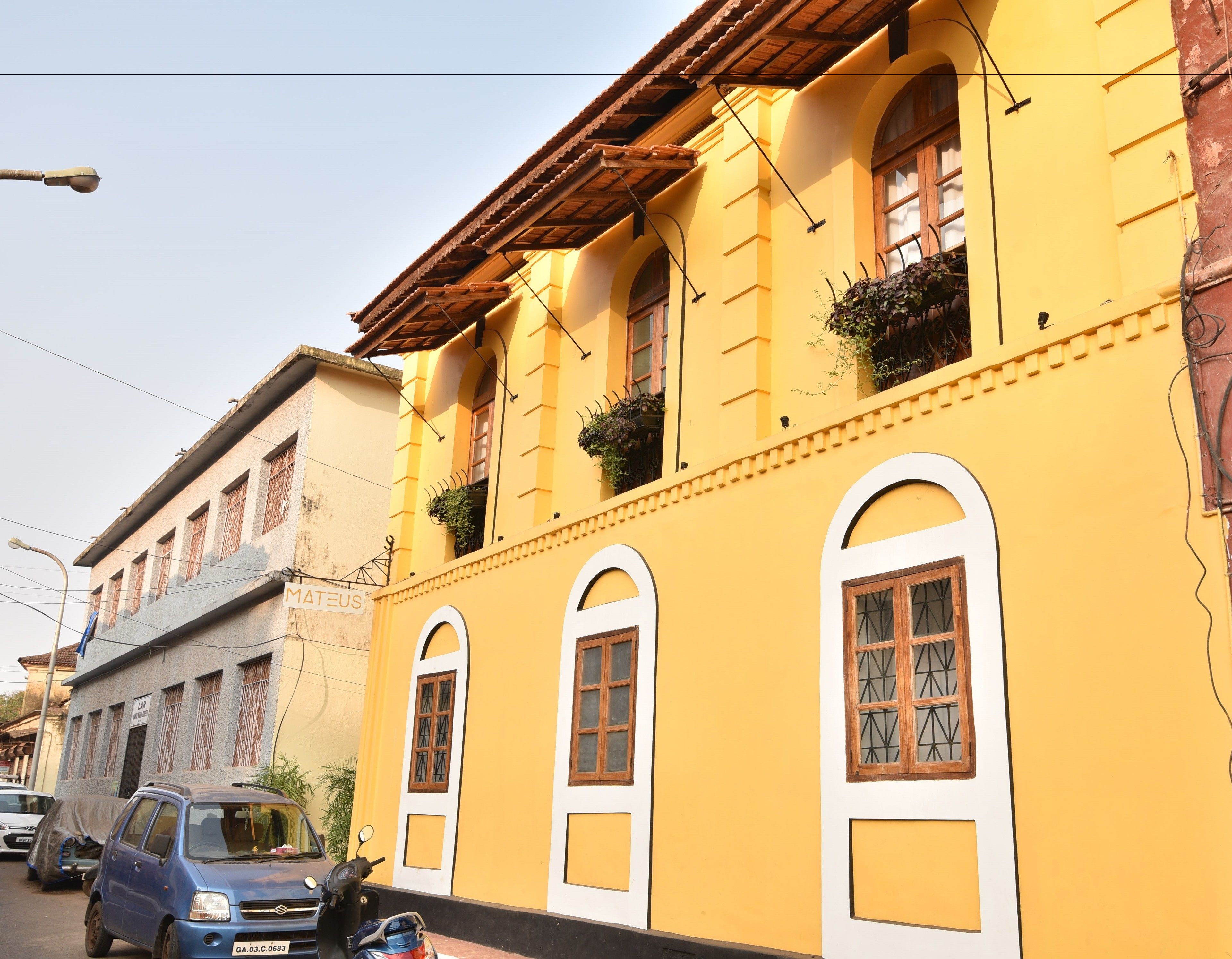 A yellow building with arched windows and a tiled roof.