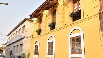 A yellow building with arched windows and a tiled roof.