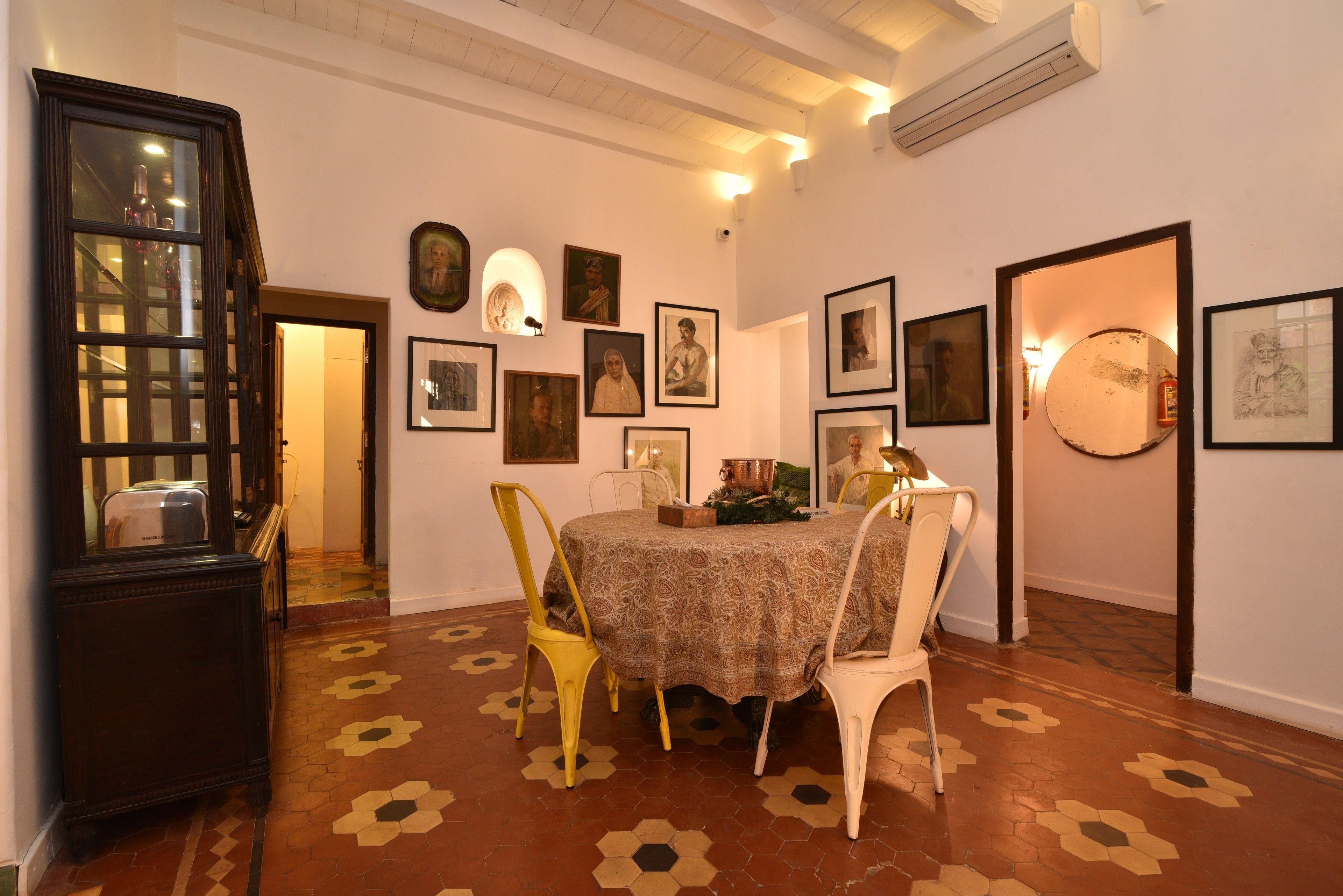 A dining area with a round table, chairs, and a patterned floor.