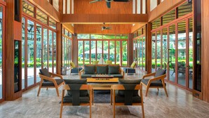 A spacious indoor area with a wooden ceiling, large windows, and a central seating area with sofas and chairs. - La Isla Pranburi Beach Resort (Sam Roi Yot)