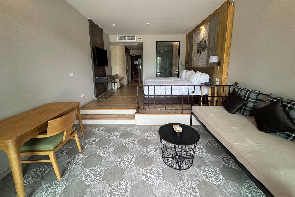 Een moderne woonkamer met een bank, een klein rond tafeltje en een houten bankje.