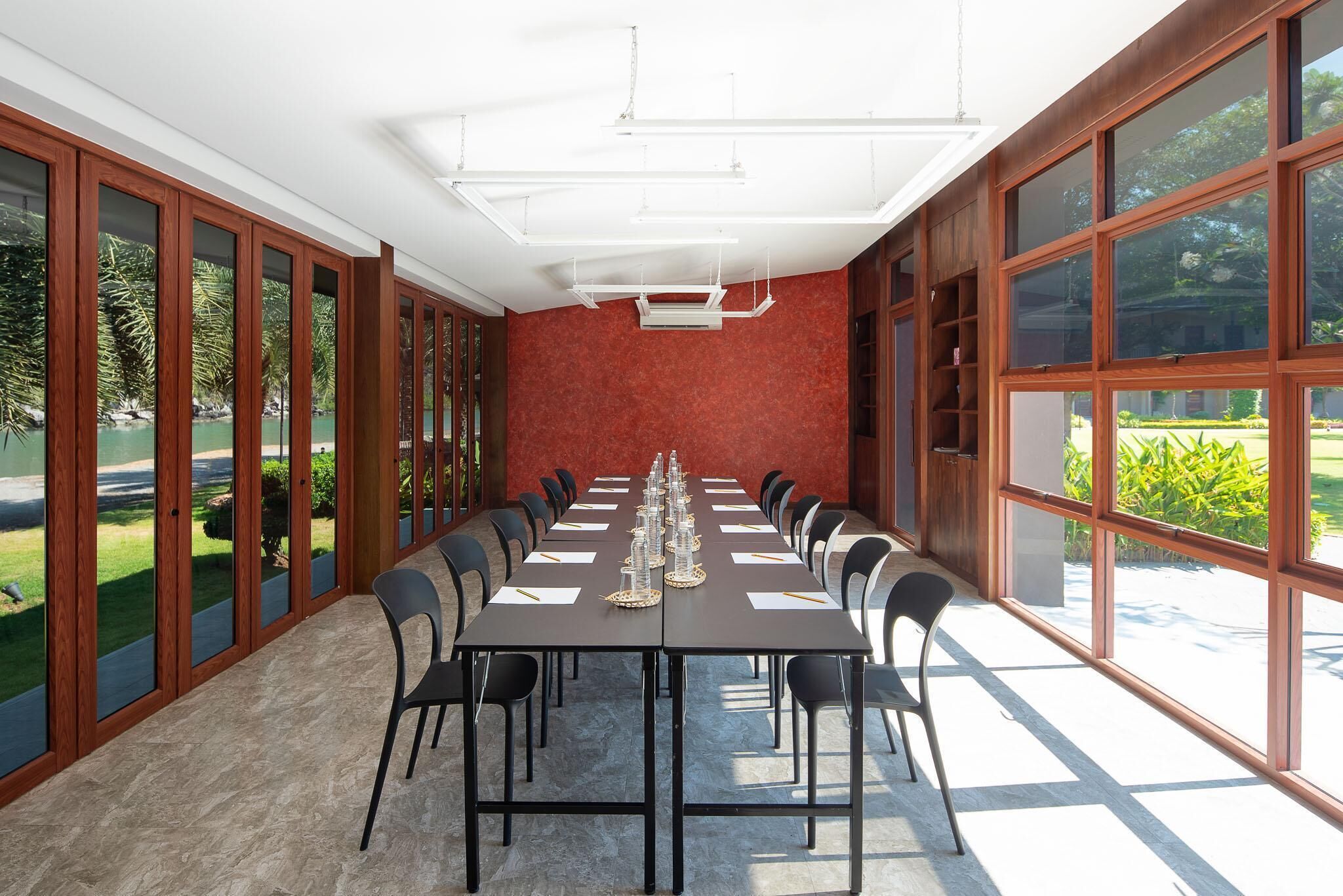 A conference room with a long table, chairs, and large windows.