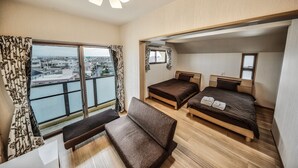 Una habitación con dos camas, un banco y una ventana con vista a edificios.
