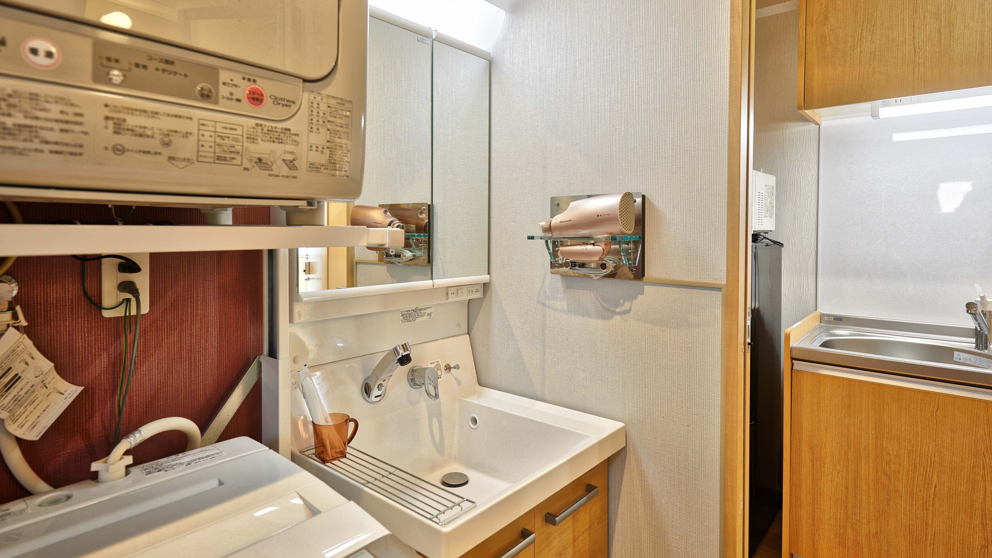 Un bagno d'albergo piccolo ma funzionale, con lavandino, specchio e asciugatrice.