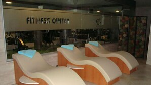 A fitness center with three massage chairs and a mirrored wall. - Sivas Buyuk Hotel (Sivas)